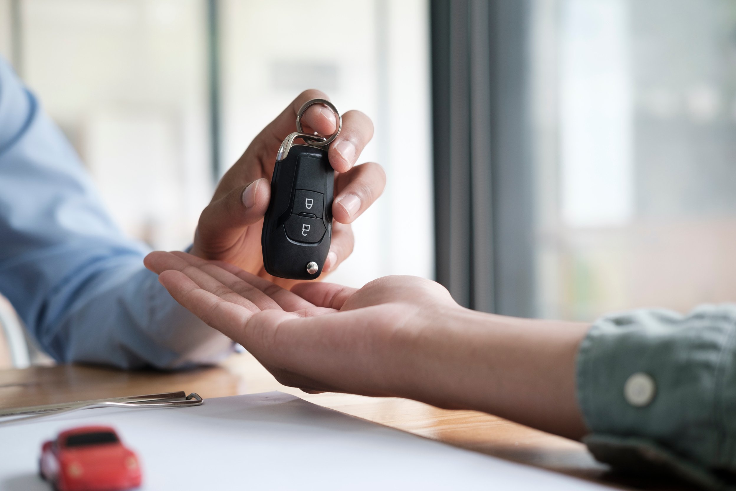 Person Handing Key with car and Document 